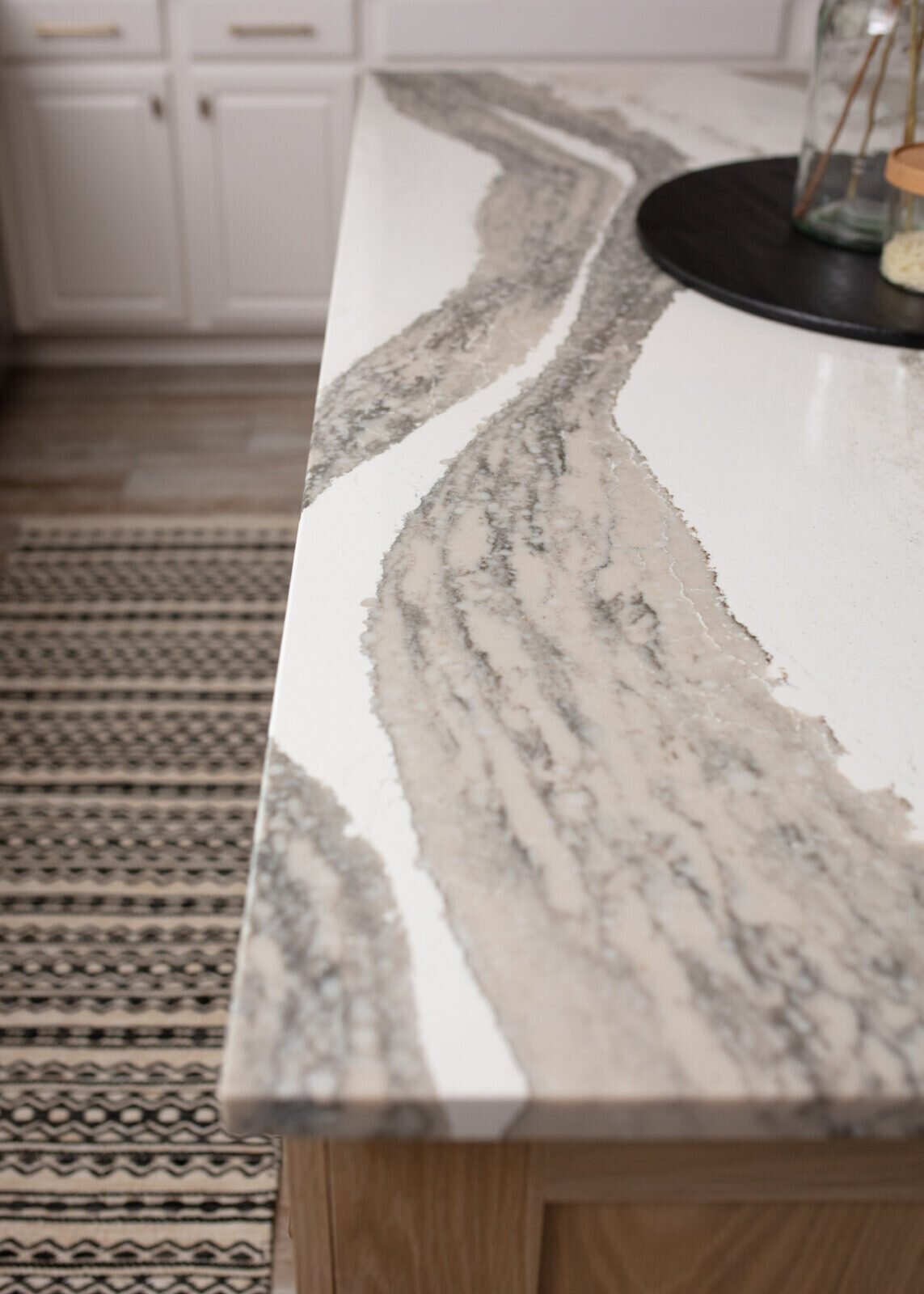 Veined quartz countertop meeting the herringbone tile backsplash in the Ambrose Kitchen project by Jennifer Kizzee Design