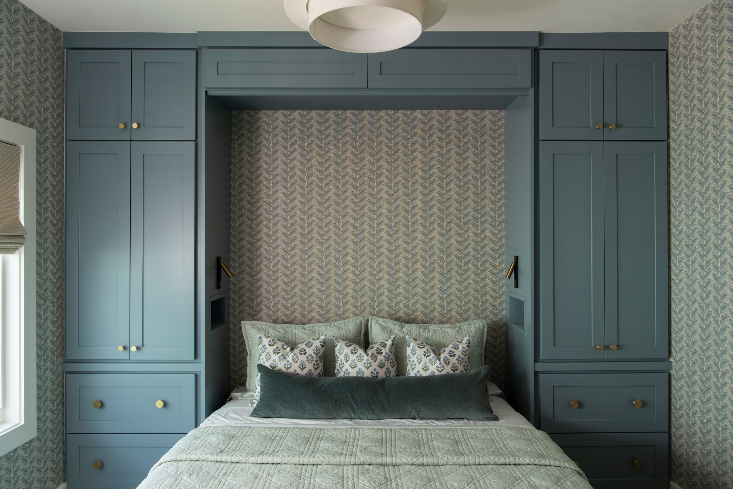 Bunk room with beds built into blue grey cabinetry under a papered niche in the Bolivar Beach House project by Jennifer Kizzee Design