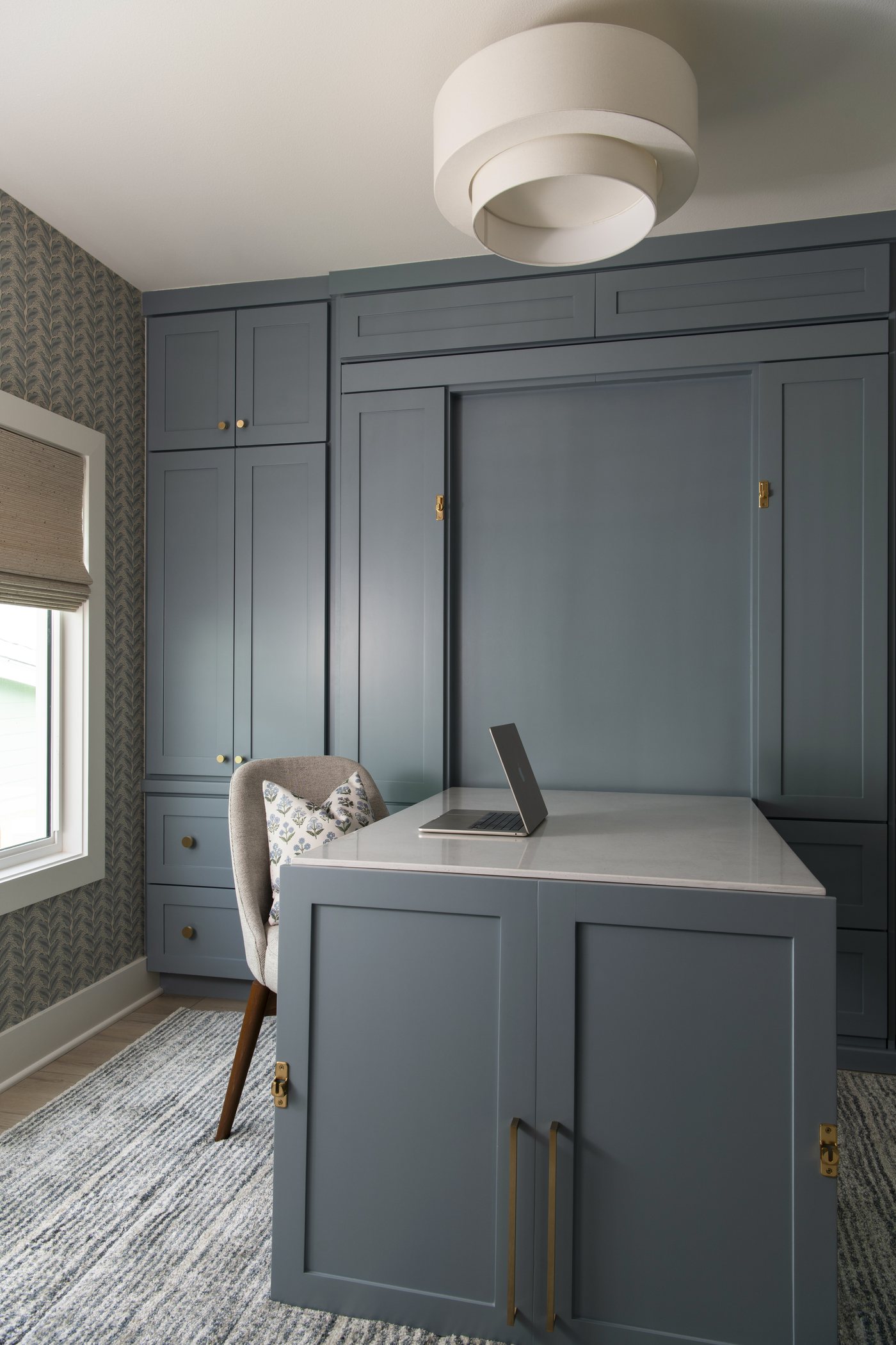 Fold down desk open against the blue grey built ins in the bunk room in the Bolivar Beach House project by Jennifer Kizzee Design