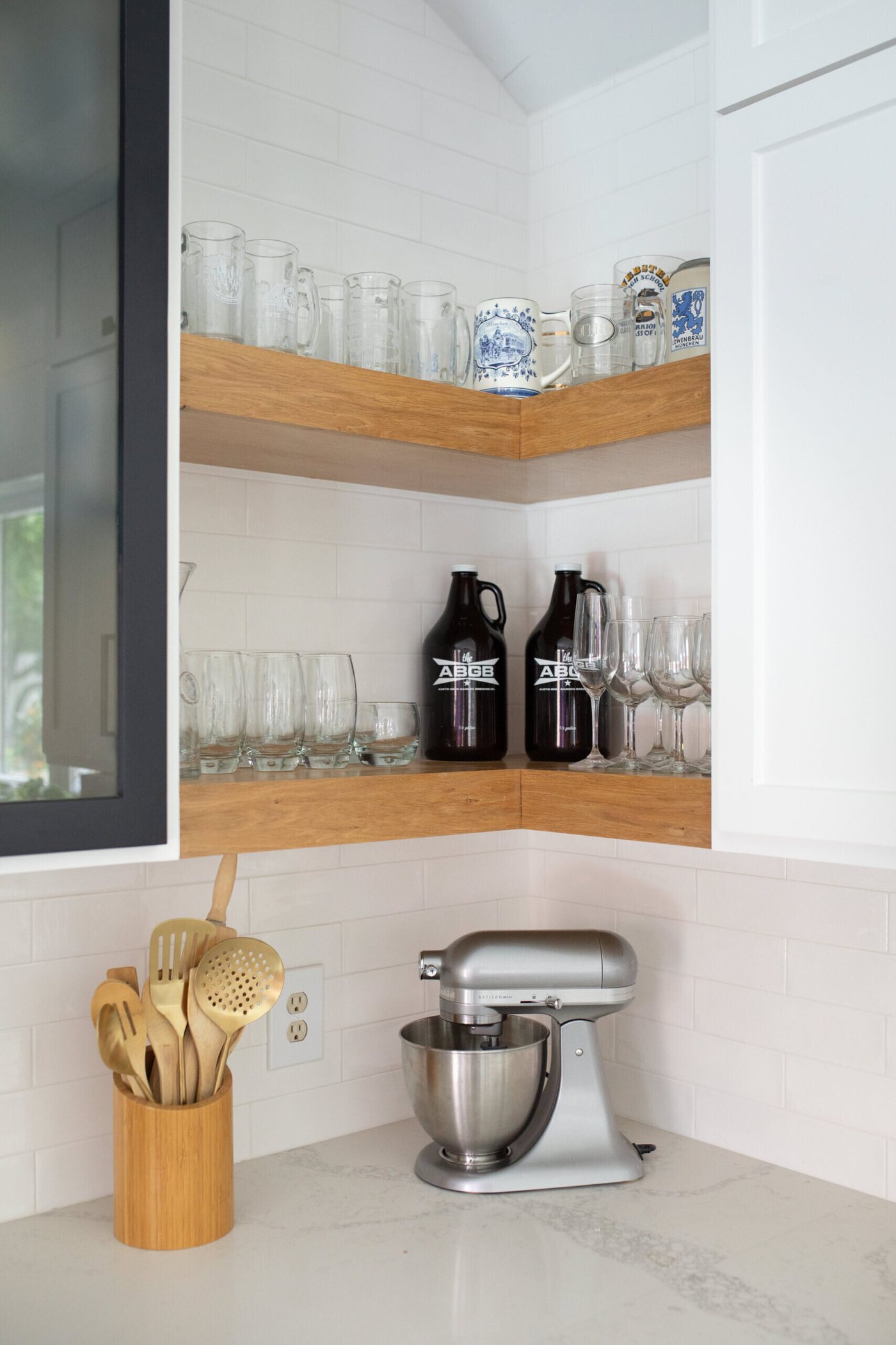 Corner shelf in white oak holding glassware beside a stand mixer in the Branstetter Kitchen project by Jennifer Kizzee Design