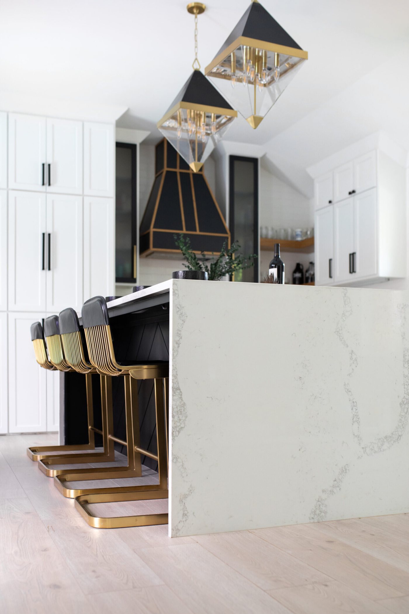 Kitchen under a vaulted ceiling with the black hood centered on white cabinetry in the Branstetter Kitchen project by Jennifer Kizzee Design