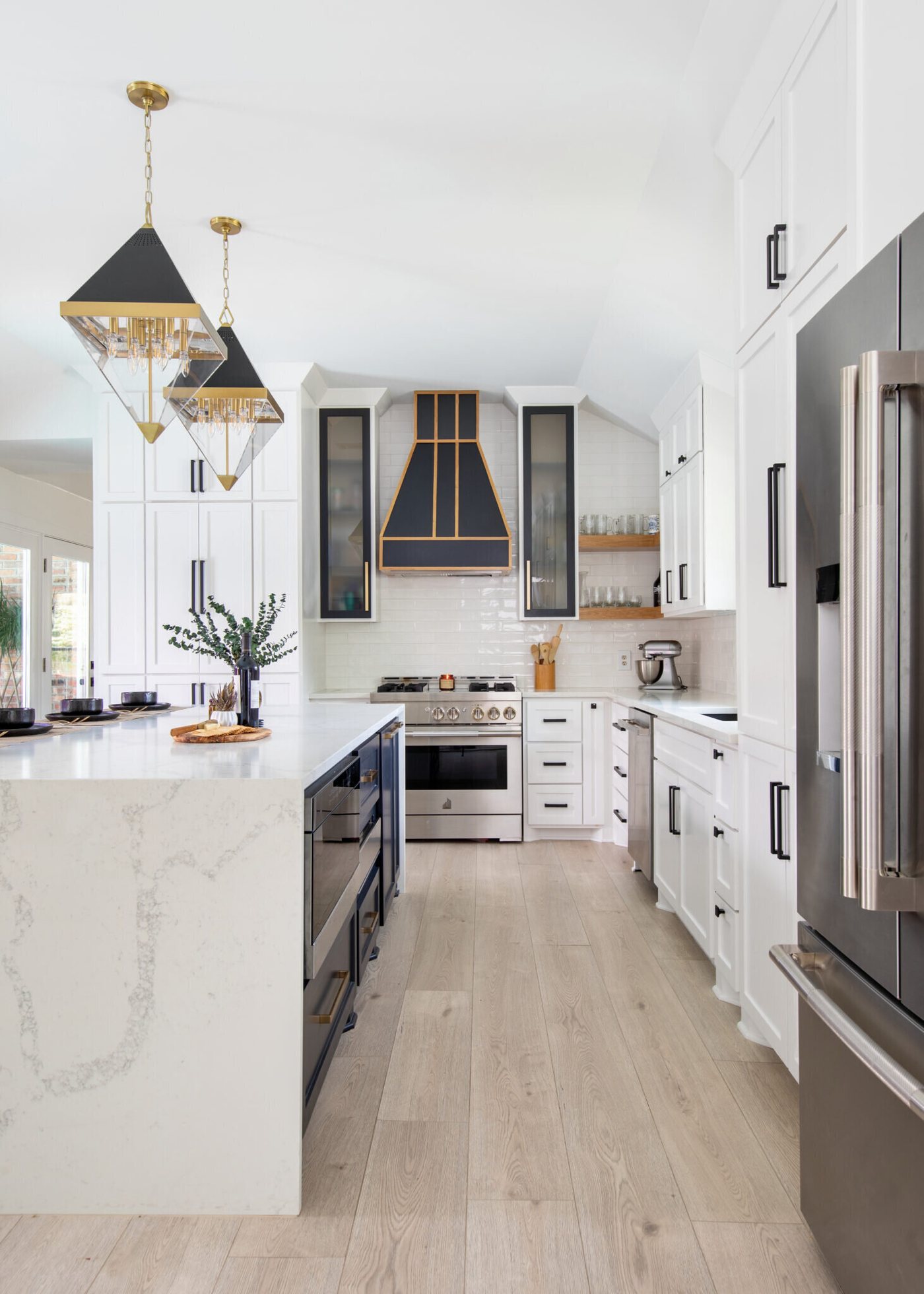 Long view of the kitchen with the island, hood and paneled refrigerator in the Branstetter Kitchen project by Jennifer Kizzee Design