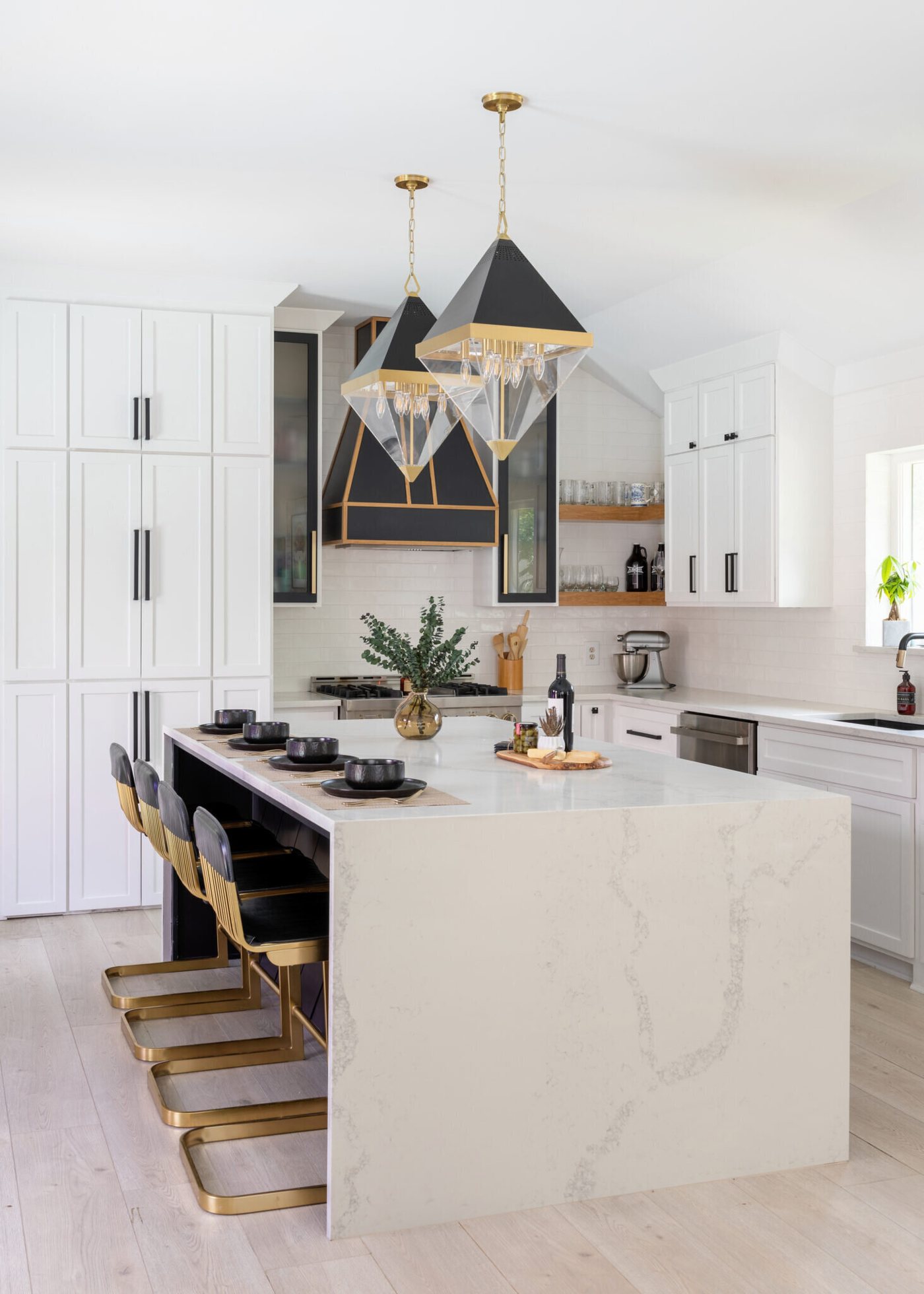 Quartz island with waterfall edge and gold and black counter stools in the Branstetter Kitchen project by Jennifer Kizzee Design