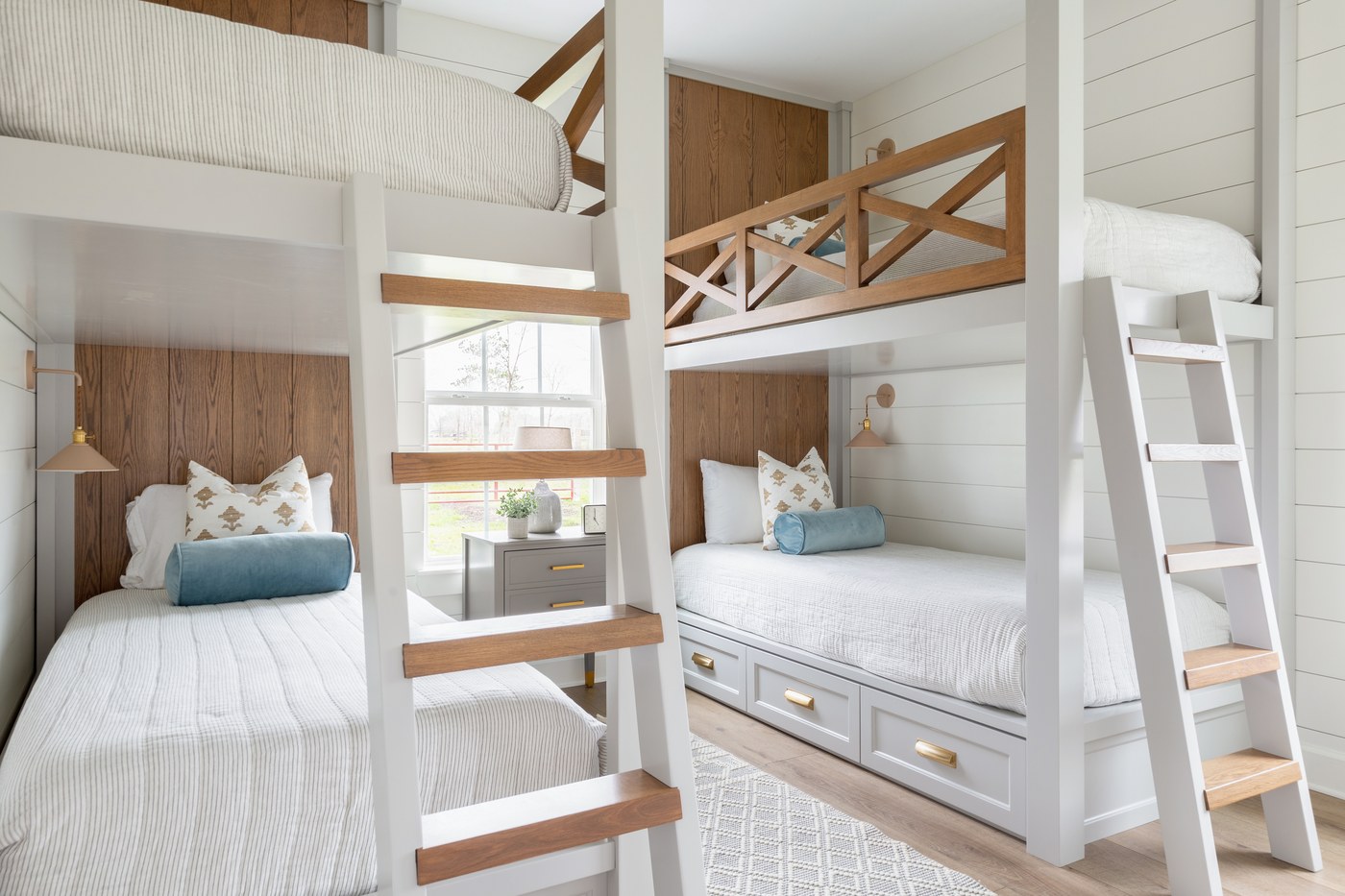 Bunk room with two built-in bunk stacks, oak X-brace guard rails, and stained plank headboard walls in the Emma Lane Guest House project by Jennifer Kizzee Design