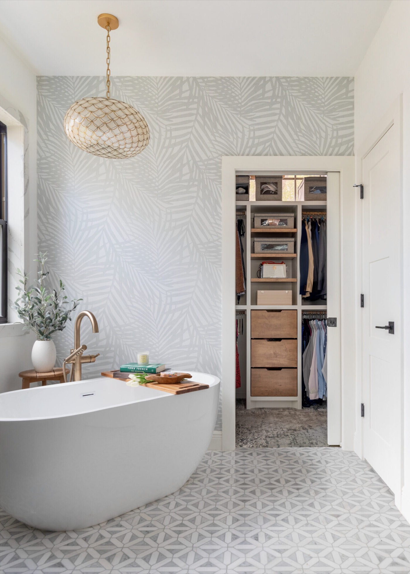 Freestanding tub with the fitted walk-in closet visible through the open doorway in the Evergreen Suite Bathroom project by Jennifer Kizzee Design