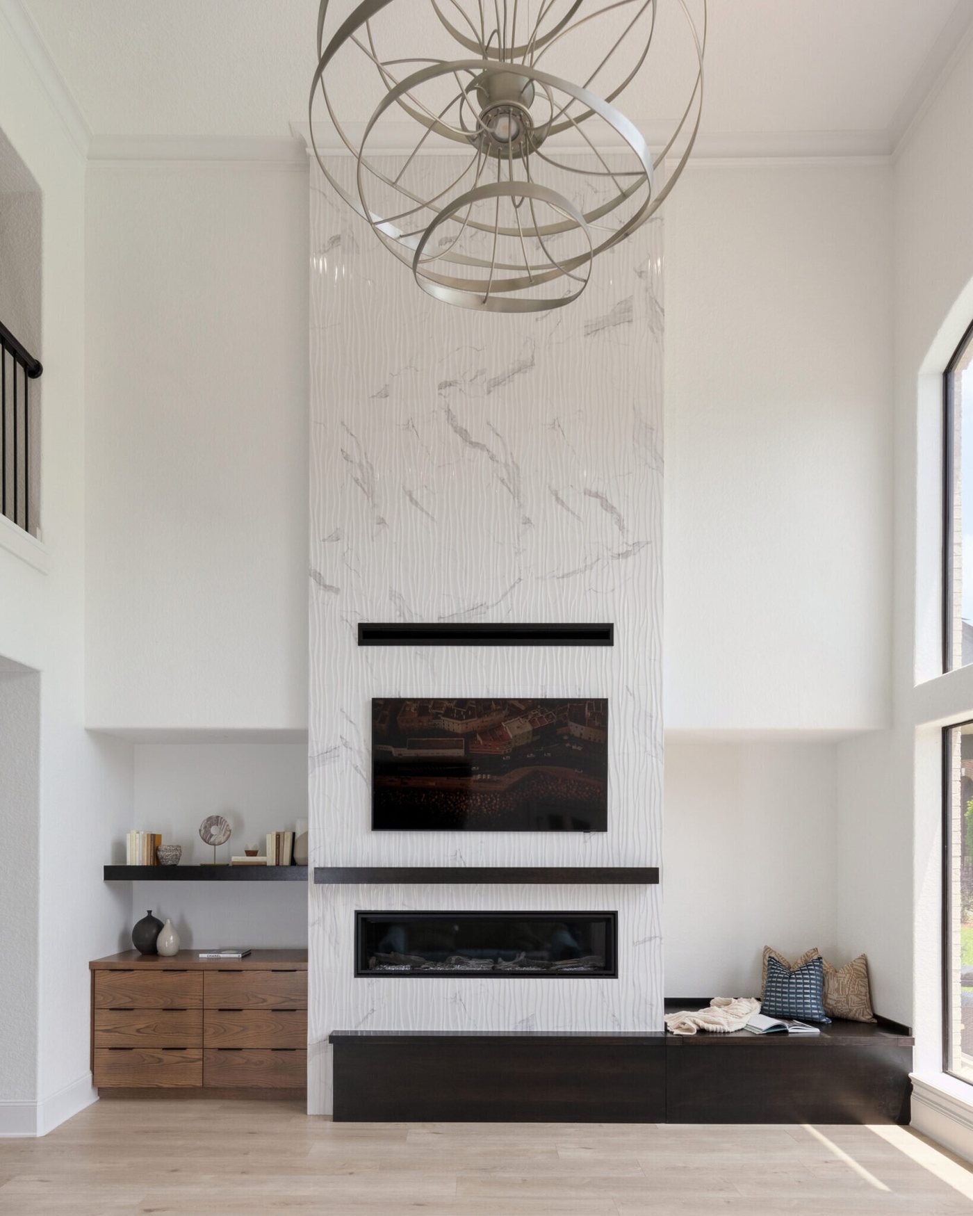 Living room fireplace faced in marble slab with walnut cabinetry beside it in the Fox Run Modern Kitchen project by Jennifer Kizzee Design
