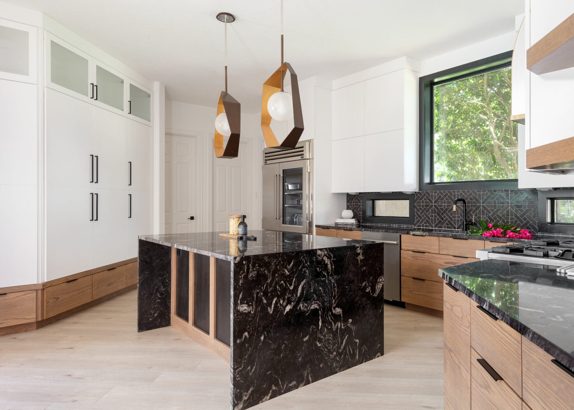 Modern kitchen with walnut cabinetry and a black island in the Fox Run Modern Kitchen project by Jennifer Kizzee Design