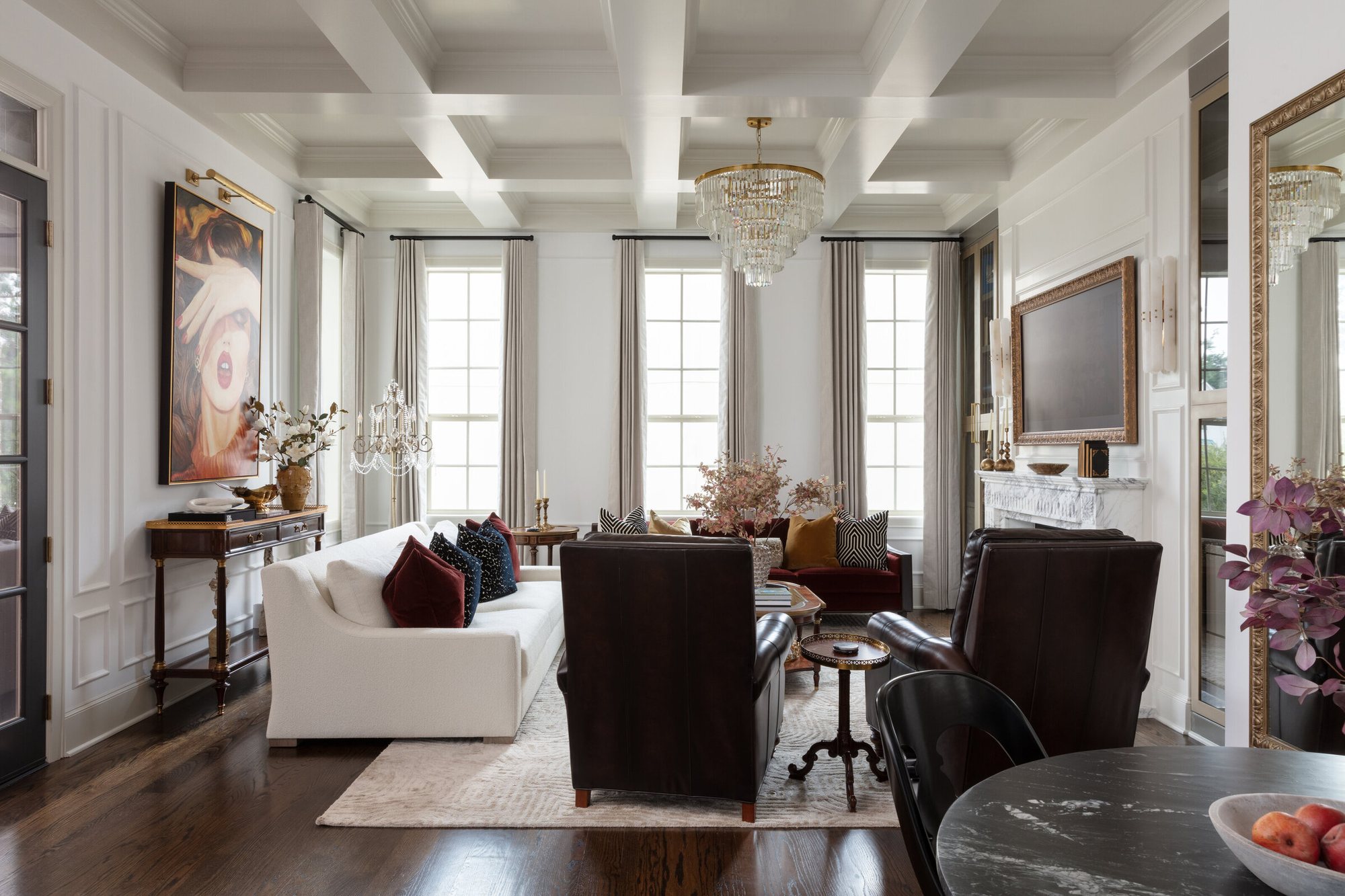 Living room under a coffered ceiling with white sofas and dark leather chairs in the Gateway Condo project by Jennifer Kizzee Design in The Woodlands, Texas