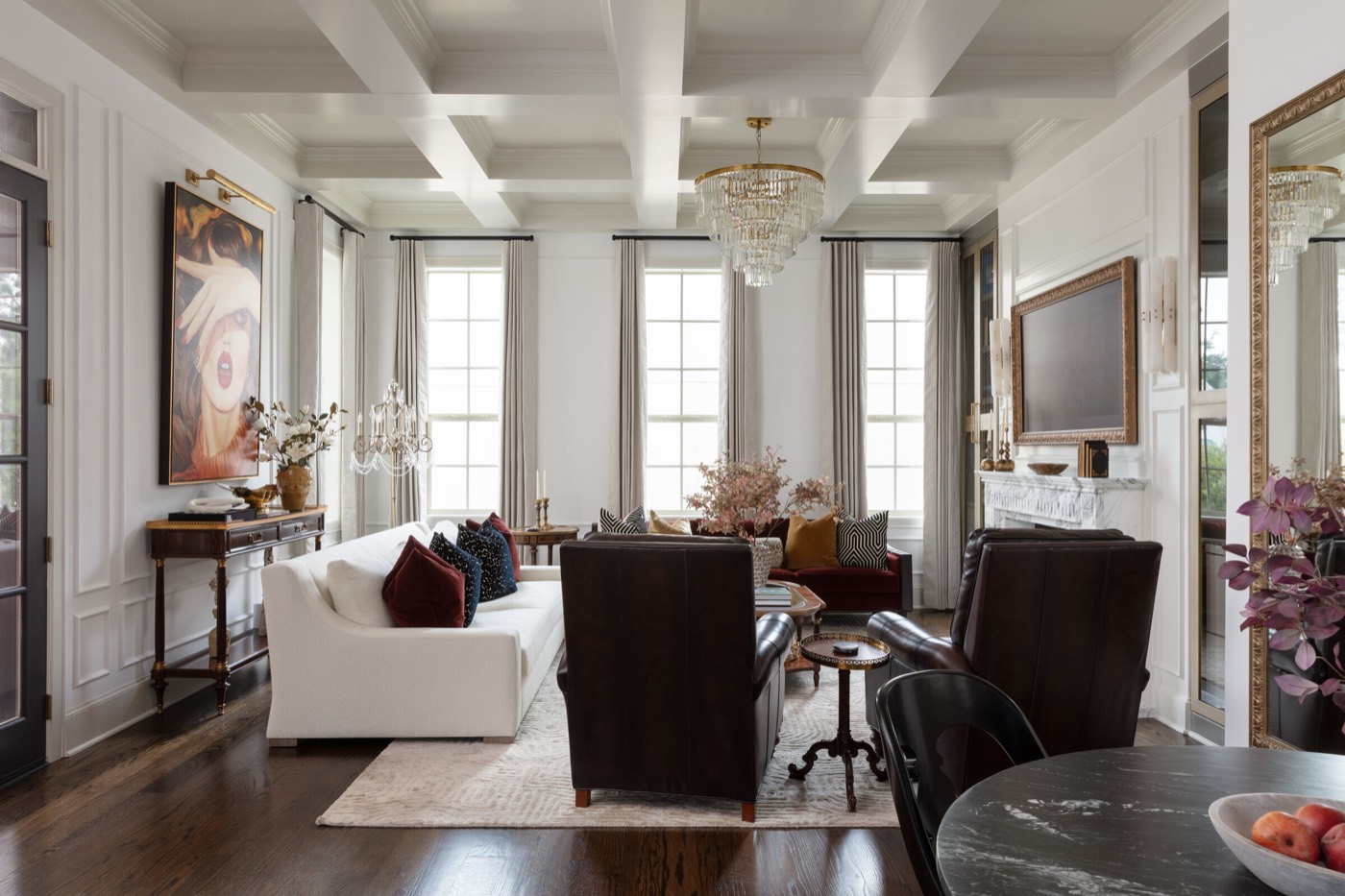 Living room under a coffered ceiling with a marble fireplace and a gilt painting in the Gateway Condo project by Jennifer Kizzee Design