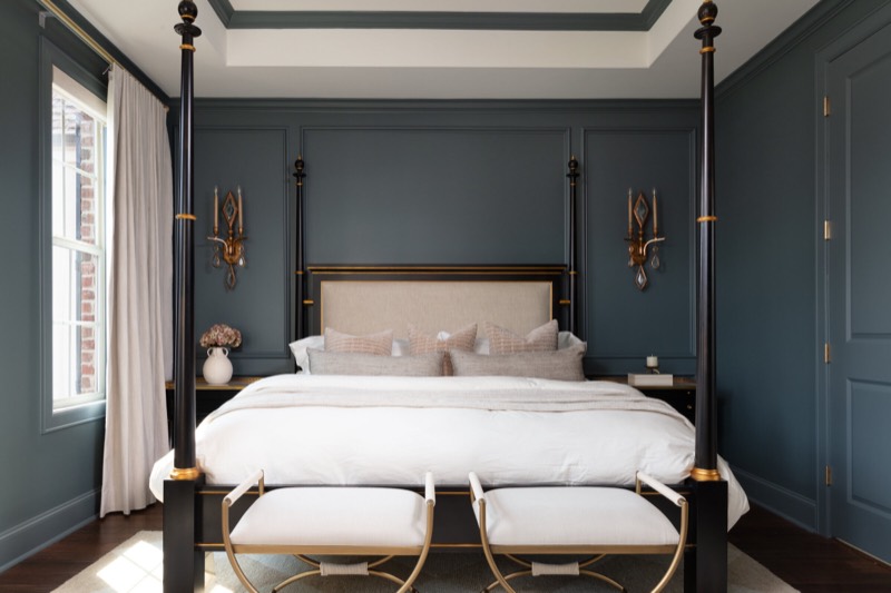 Primary bedroom with dark teal paneled walls and a black and gilt four-poster bed in the Gateway Condo project by Jennifer Kizzee Design in The Woodlands, Texas