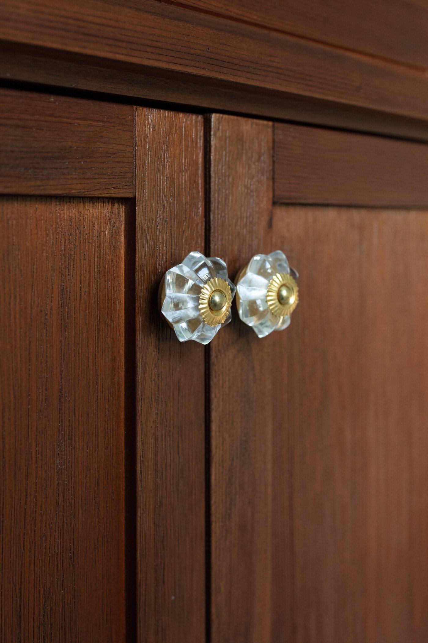 Glass knob on a walnut cabinet door in the Heights Primary Bath project by Jennifer Kizzee Design