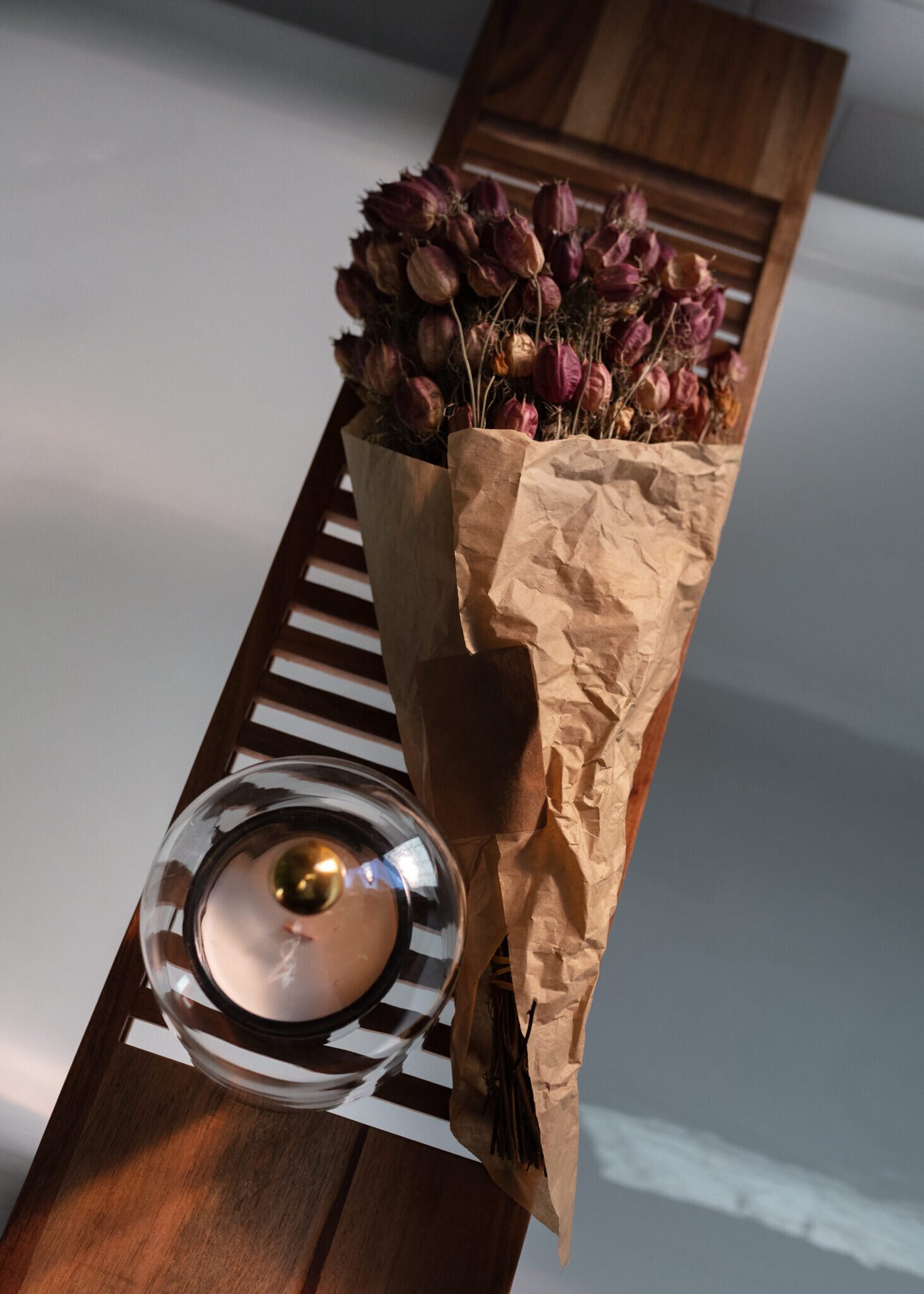 Walnut bath caddy holding dried roses across a clawfoot tub in the Heights Primary Bath project by Jennifer Kizzee Design