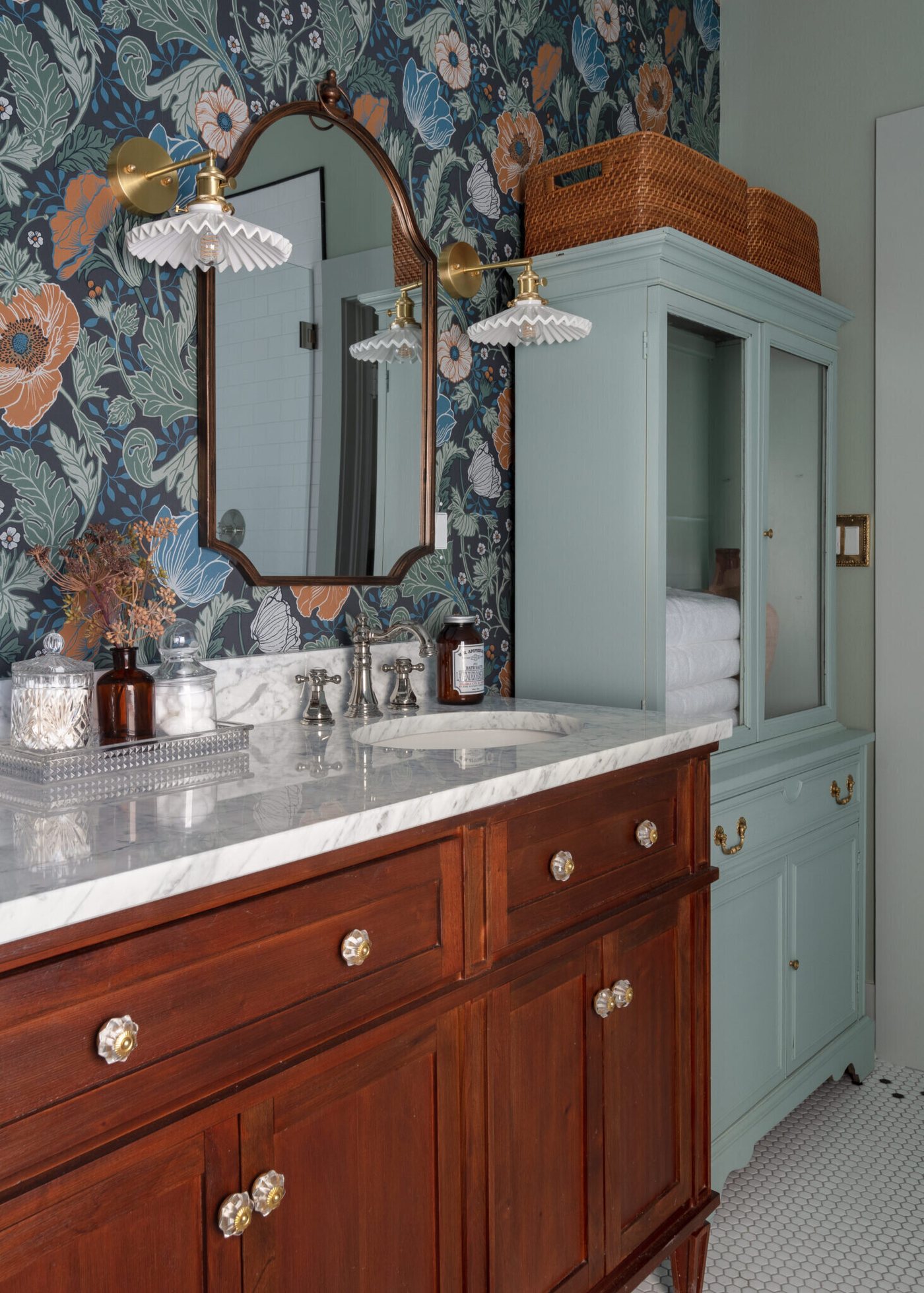 Walnut vanity meeting mint green cabinetry under an arched mirror in the Heights Primary Bath project by Jennifer Kizzee Design