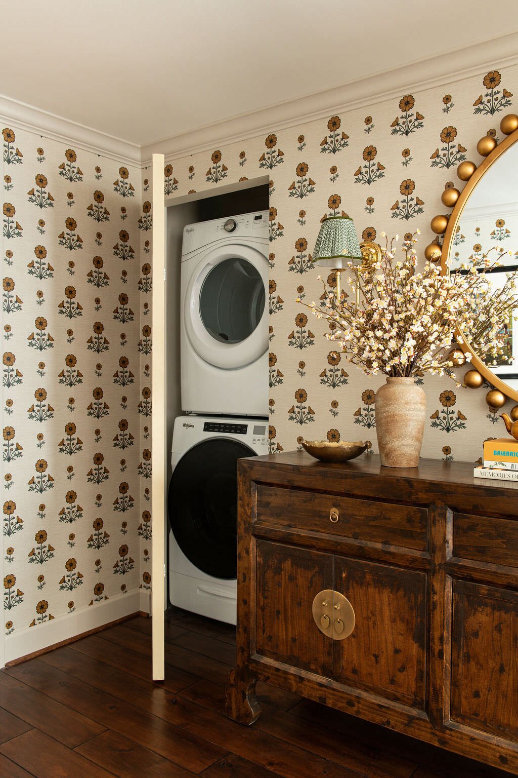 Laundry hidden behind papered doors beside the antique chest in the Holcombe Condo project by Jennifer Kizzee Design