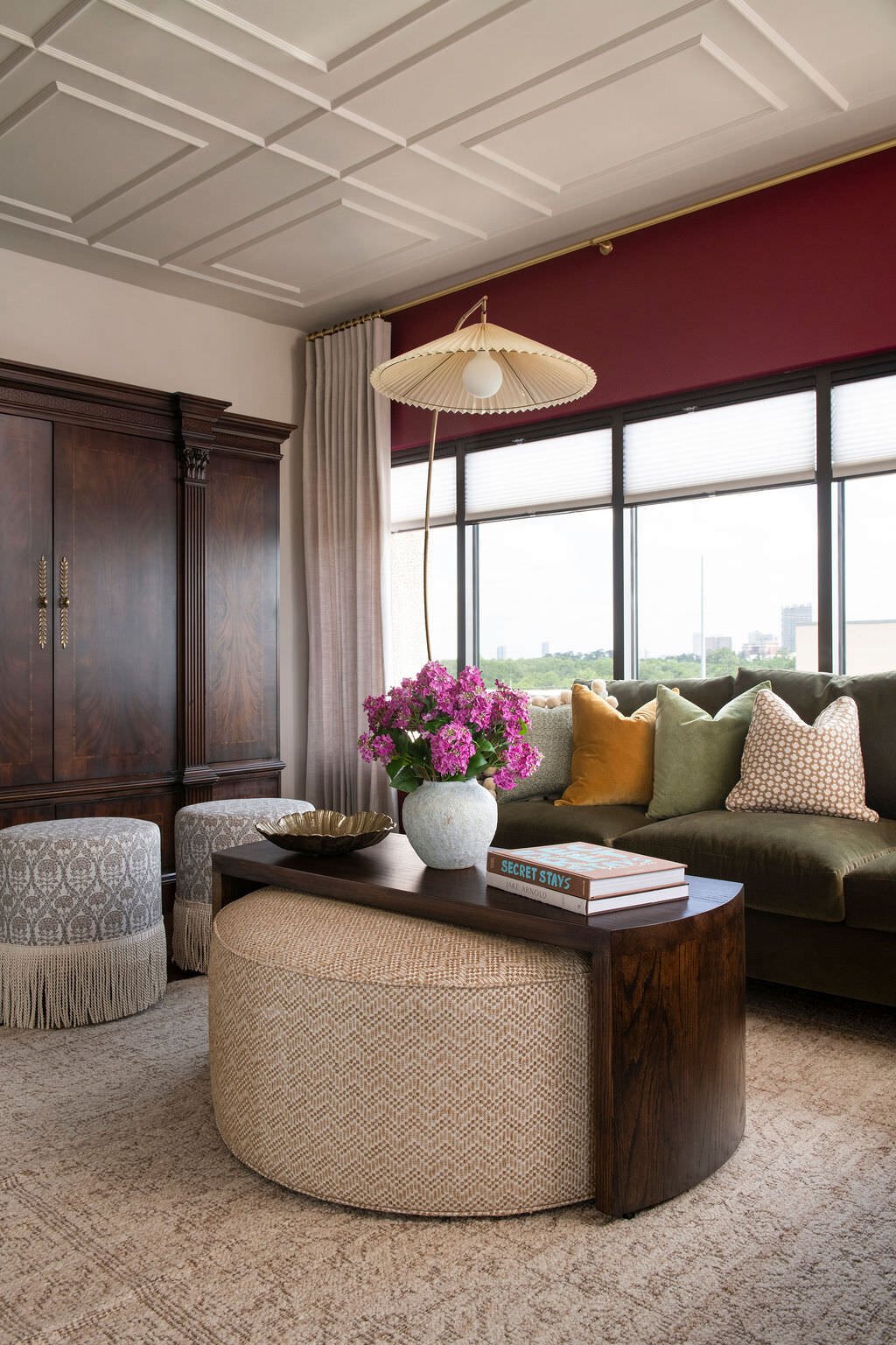Olive sectional and round ottoman in the living room with a woven pendant above in the Holcombe Condo project by Jennifer Kizzee Design