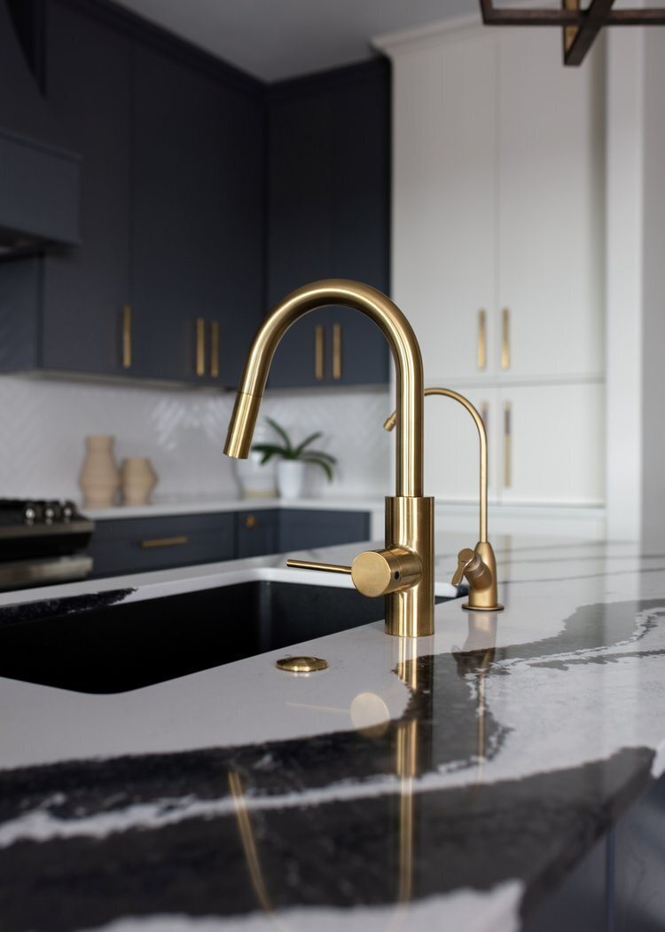 Brass faucet over a black undermount sink in black granite in the Longwood project by Jennifer Kizzee Design
