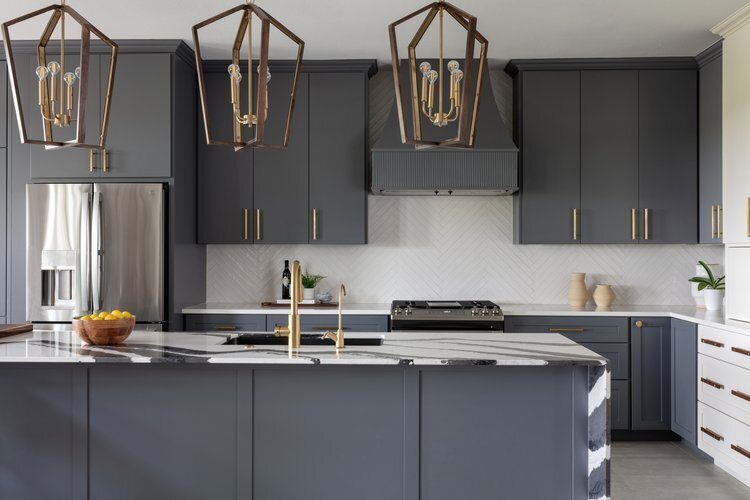 Charcoal cabinetry along the range wall with white herringbone tile behind it in the Longwood project by Jennifer Kizzee Design