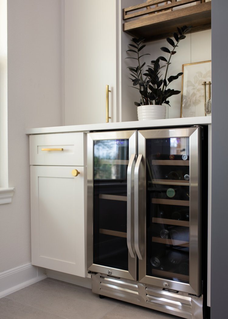 Glass front beverage refrigerators under a counter with open shelves above in the Longwood project by Jennifer Kizzee Design