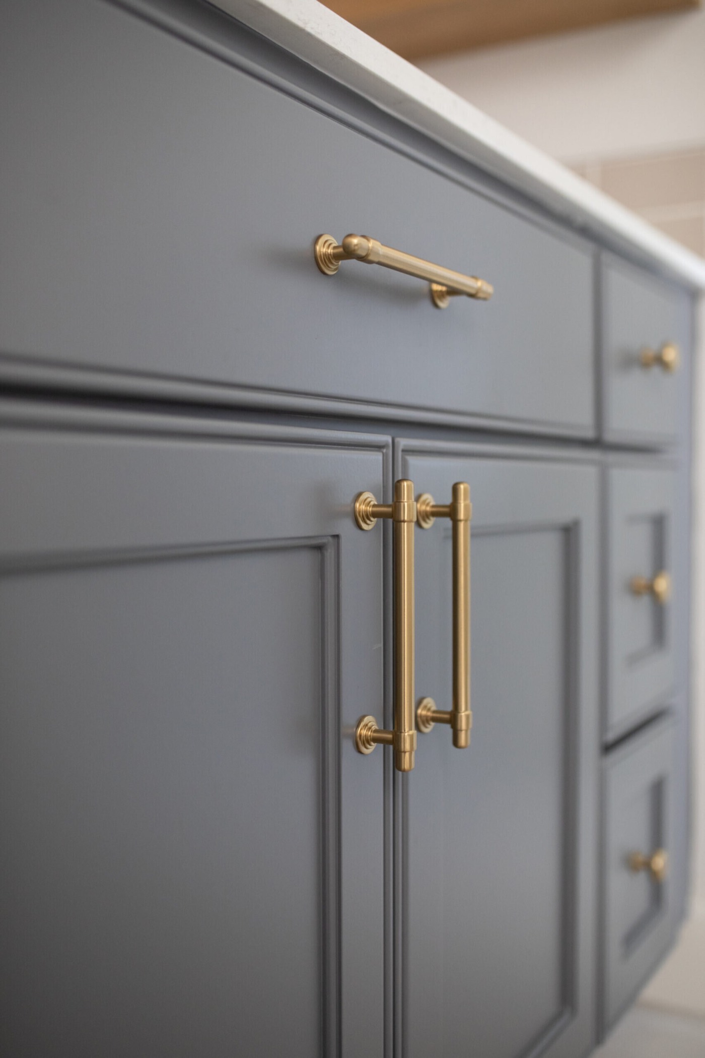 Brass bar pull and T-knobs on slate gray shaker vanity doors in the Mountain Falls Primary Bath project by Jennifer Kizzee Design