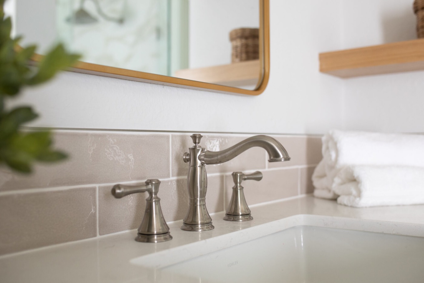Brushed nickel widespread faucet on a quartz counter against greige glazed subway tile in the Mountain Falls Primary Bath project by Jennifer Kizzee Design