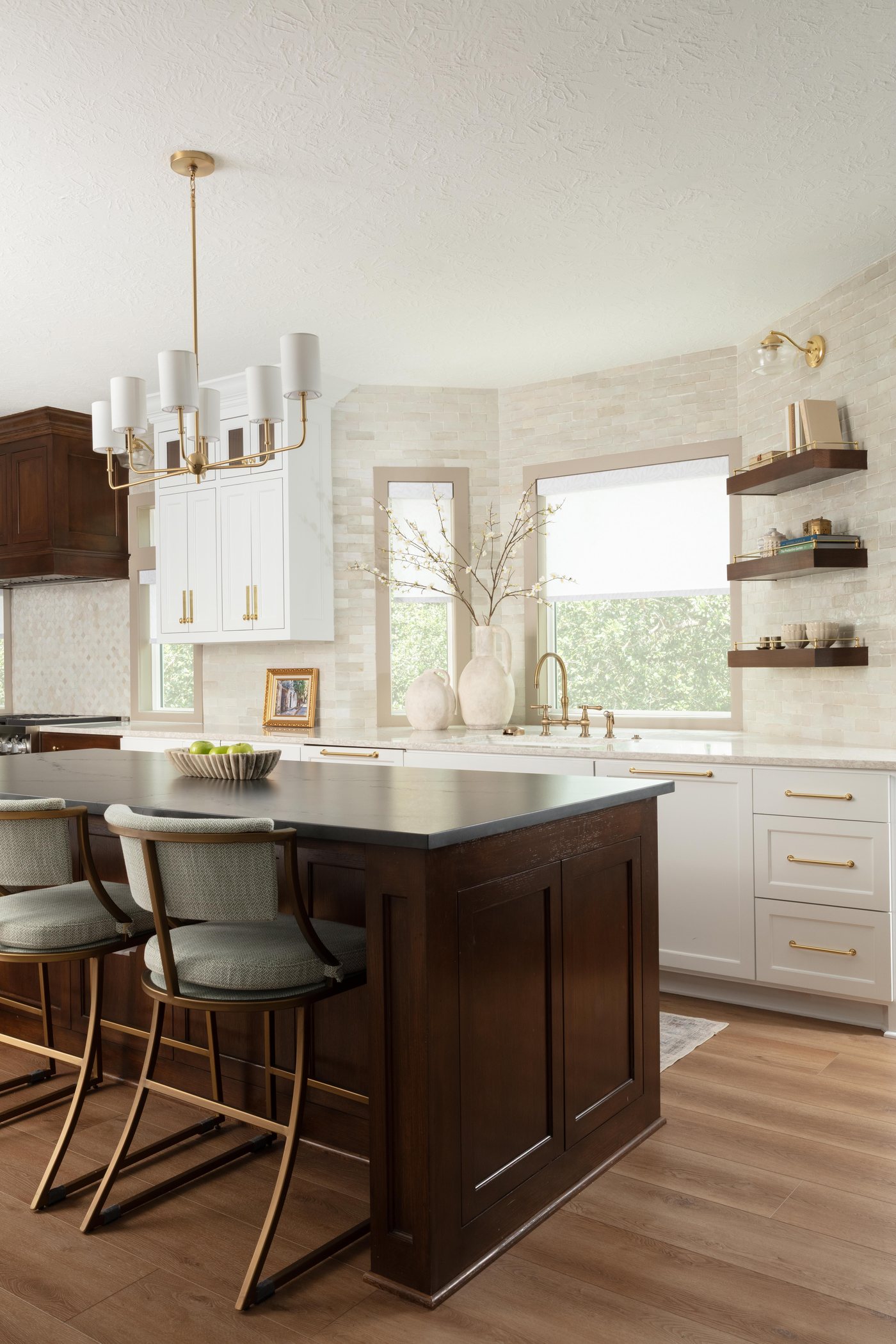 Island with green leather stools beside a window and open shelves in the Pebble Brook project by Jennifer Kizzee Design
