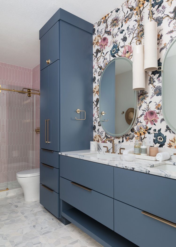 Navy double vanity with round mirrors under floral wallpaper in the Pine Lodge project by Jennifer Kizzee Design