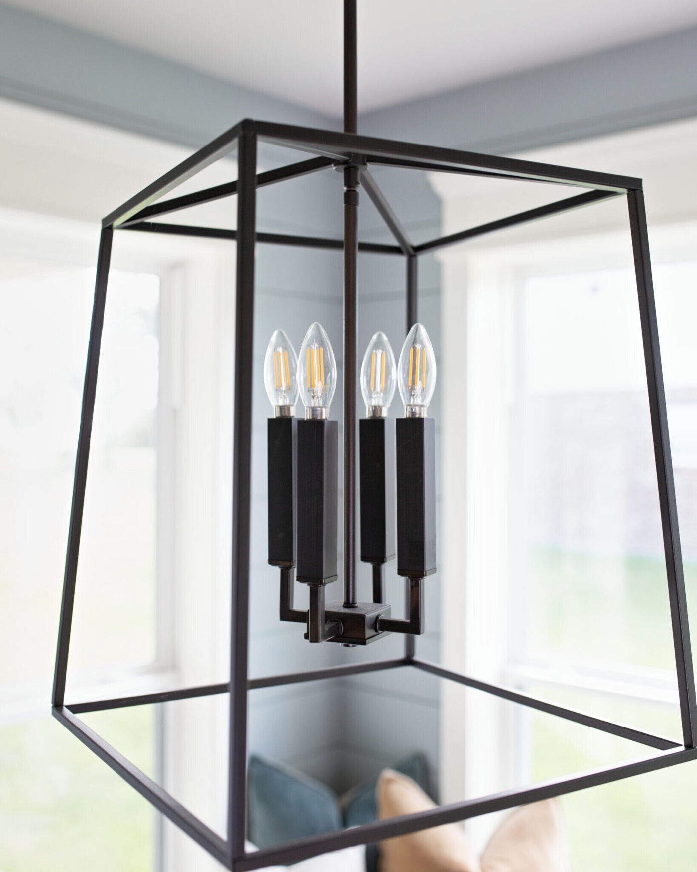 Black iron cage lantern with four candle bulbs above the breakfast table in the Silver Moon project by Jennifer Kizzee Design