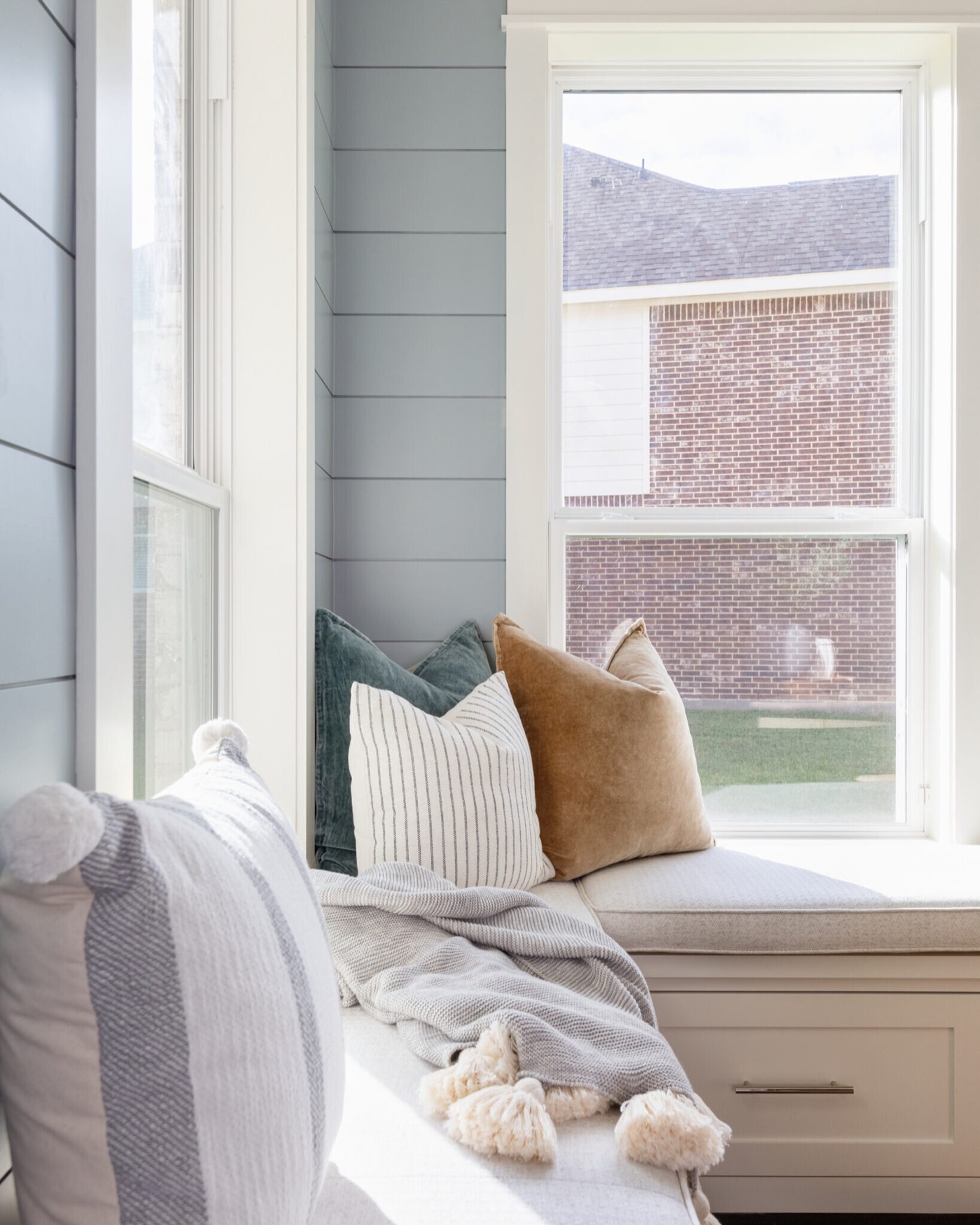Teal velvet, ticking stripe and camel pillows on the window bench cushion in the Silver Moon project by Jennifer Kizzee Design