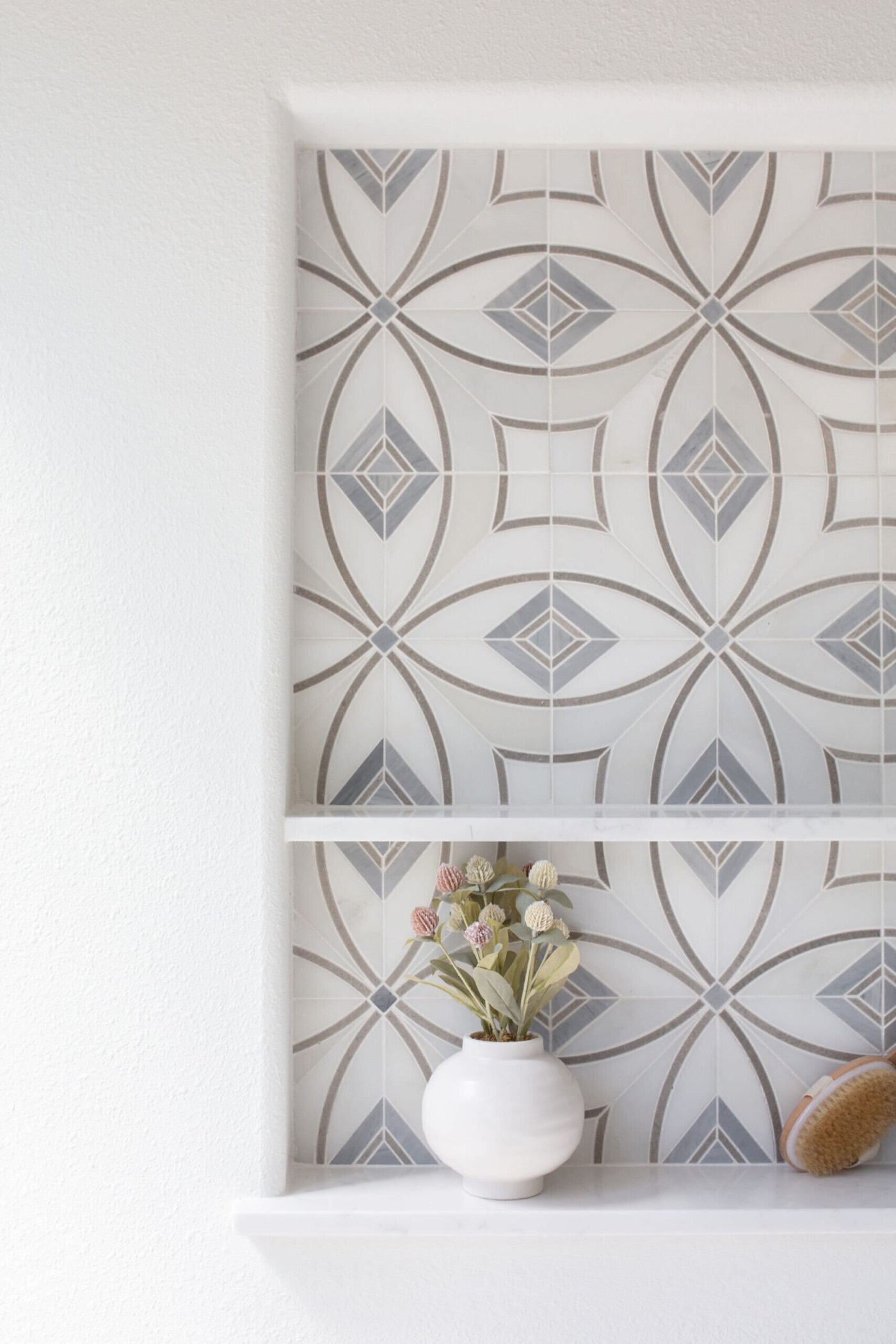 Gray and white circle and diamond patterned tile set into the recessed display niche in the Sunstream Bath project by Jennifer Kizzee Design