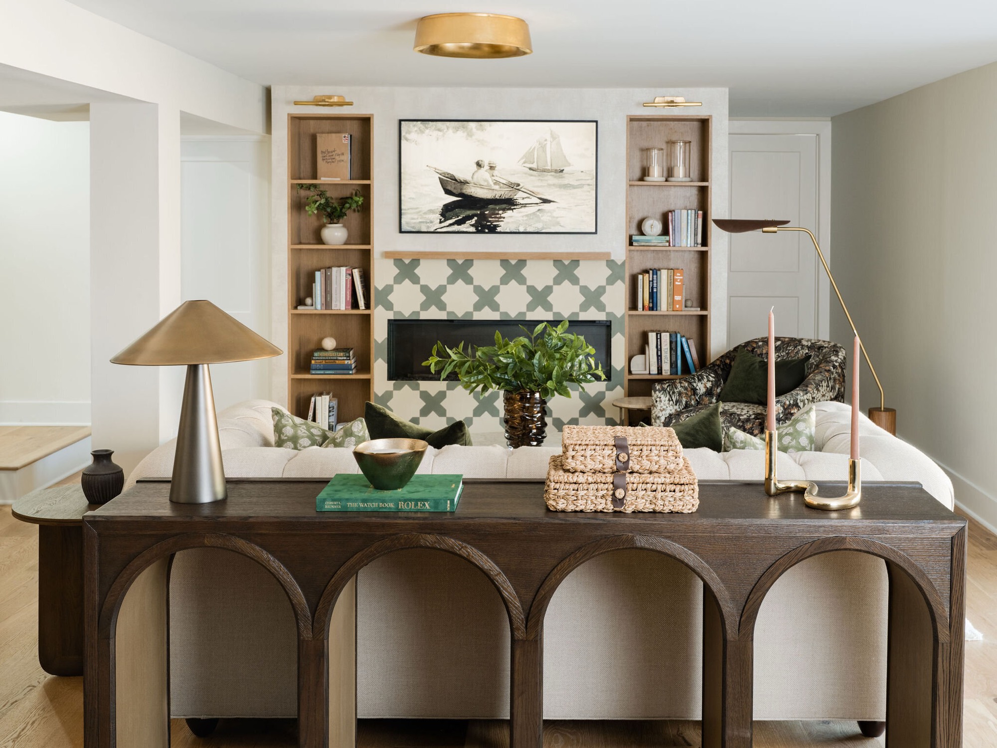 Living room with a linear gas fireplace set in green and white quatrefoil tile between pale oak built in bookcases in the Takoma Park project by Jennifer Kizzee Design